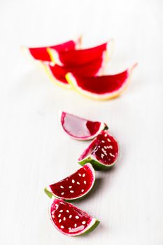 Watermelon like tequila  jelly (jello) shots made out of carved lime on bleached wooden table. Unusual adult party drinks