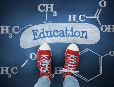 The word education and casual shoes against blue chalkboard
