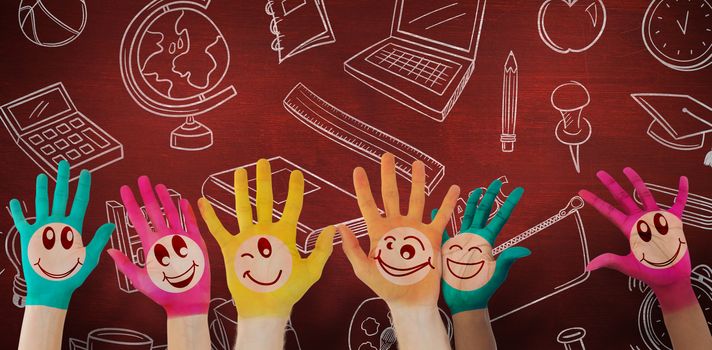 Hands with colourful smiley faces against desk