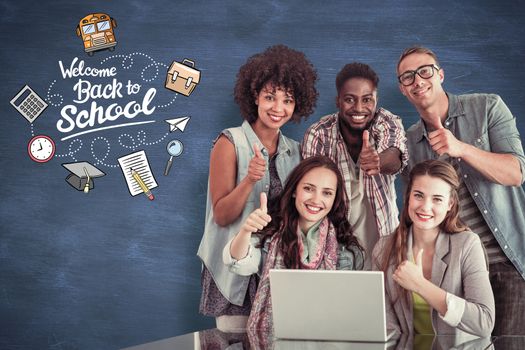 Fashion students working as a team  against blue chalkboard