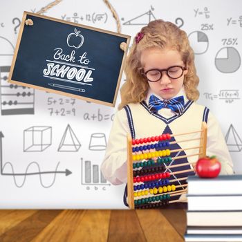 Pupil holding abacus at elementary school  against wooden surface with planks