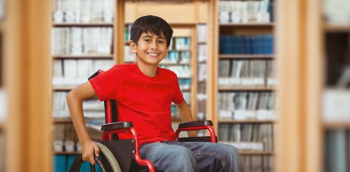 Portrait of boy sitting in wheelchair against library