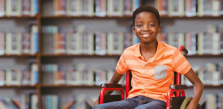 Portrait of boy sitting in wheelchair at library against library shelf