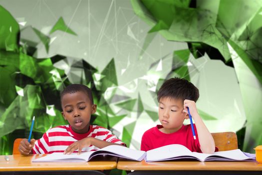 Cute pupils writing at desk in classroom against angular design