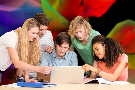College students using laptop in library against colourful abstract design