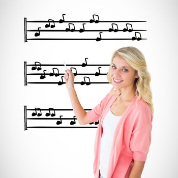 Young pretty student writing with chalk against music notes