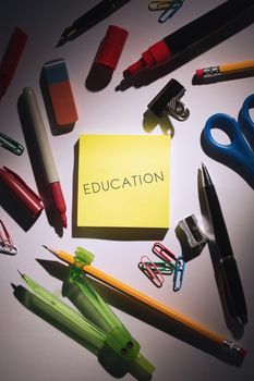 The word education against students table with school supplies