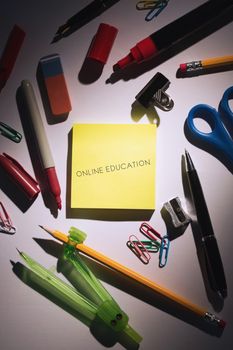 The word online education against students table with school supplies