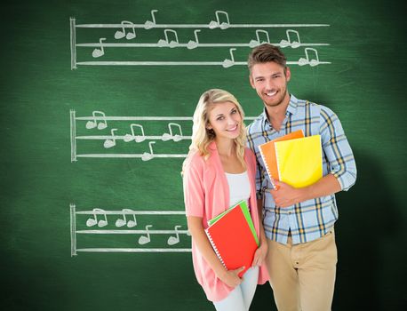 Happy students smiling at camera  against green chalkboard