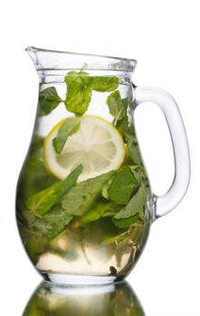 Alcoholic cocktail with mint and lemon slice in a pitcher. Full jug of mojito.