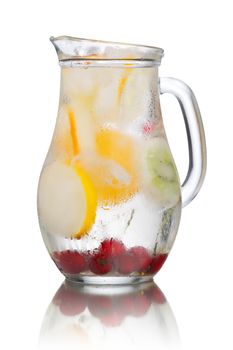 Glass pitcher of homemade detox water enriched with cherries and frozen fruit wedges. Misted jug full of cold water with popsicles. Clean eating