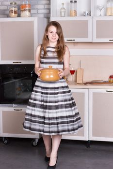 Happy ordinary woman with pan at her kitchen