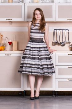 funny beautiful woman in the lush dress in kitchen