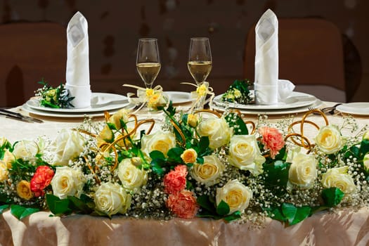 Decorated wedding table for newlyweds with two glasses of champagne.