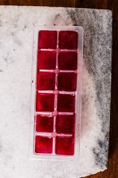 Frozen hibiscus tea also known as karkade, agua fresca or red sorrel on a marble plate