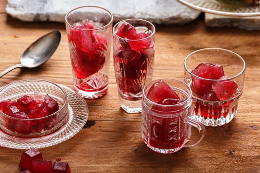 Preparation of frozen hibiscus tea also known as karkade, agua fresca or red sorrel on a wooden table