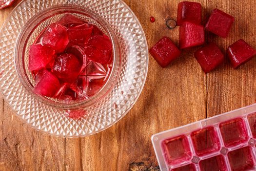 Frozen hibiscus tea also known as karkade, agua fresca or red sorrel on a wooden table
