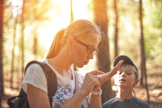 Mother and her little son find lizard in the forest