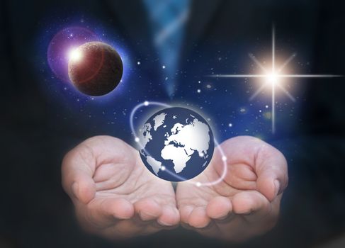 Business man holding the world in his hands surrounded by space and planets 