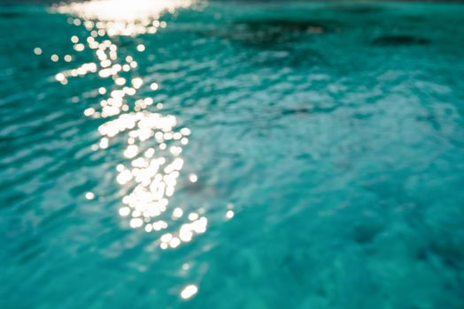 Blur green blue sea surface with reflecting sunlight evening in summer for background