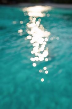 Blur green blue sea surface with reflecting sunlight evening in summer for background