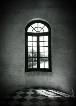 Sunlight coming through the window of an old building. Black and white photo.