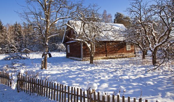   the old wooden house covered with snow in a winter season