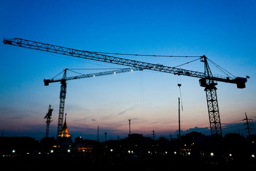 industrial landscape with silhouettes of cranes on the sunset background