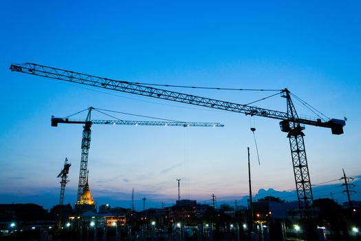 industrial landscape with silhouettes of cranes on the sunset background