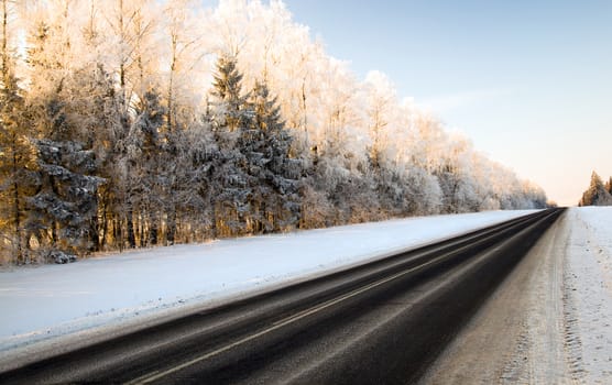 the road covered with snow in a winter season