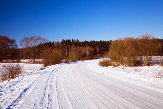 the road covered with snow in a winter season