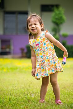 Outdoor portrait of sad little girl playing in summer park