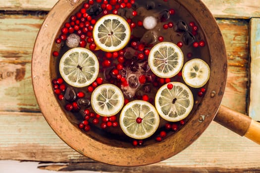 Cranberry lemon punch in a brass bowl on wooden table