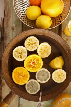 Top view of brass pot with lemonade,detox water or punch with lemons and oranges