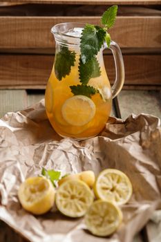 Jug of Iced lemonade with lemon balm. Rustic styled, selective focus