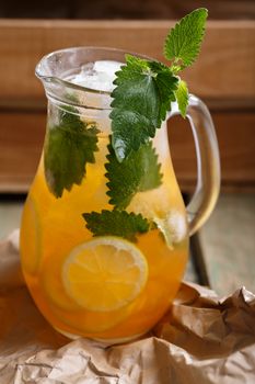 Jug of Iced lemonade with lemon balm. Rustic styled, selective focus