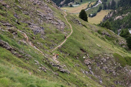 cyclists flock along the narrow path in the Swiss alps near Matterhorn 