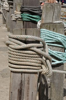 Rope tied on wooden post at dock