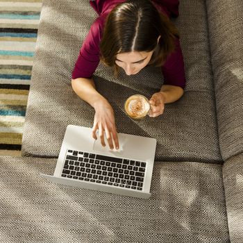 Beautiful woman at home working while drinking one capuchino