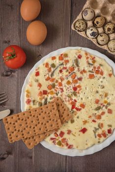 baked omelette with different eggs and vegetables with rye small load of bread