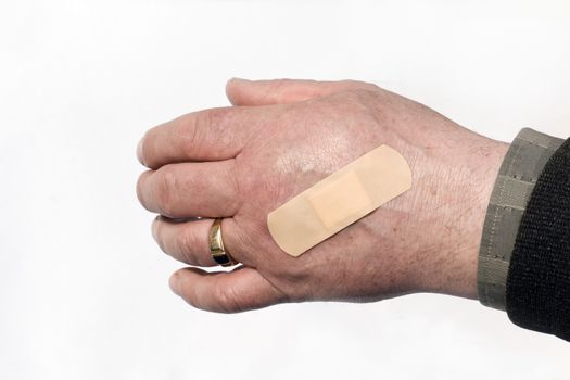 the hand of man with the pasted band-aid
