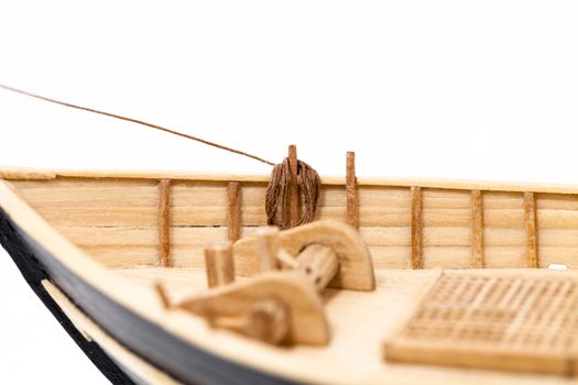   the wooden model of the ship photographed by a close up. focus on ropes