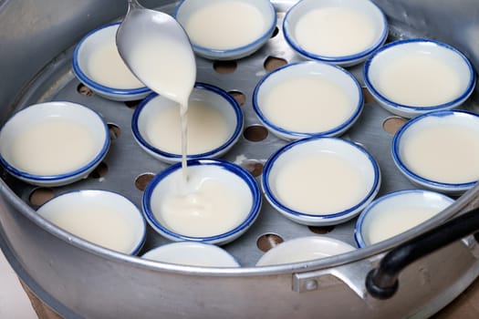 process of making coconut milk custard in small porcelain cup (Thai dessert).