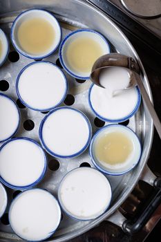 Streaming coconut milk custard in small porcelain cup (Thai dessert).