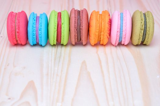 Sweet and colourful french macaroons on wooden table