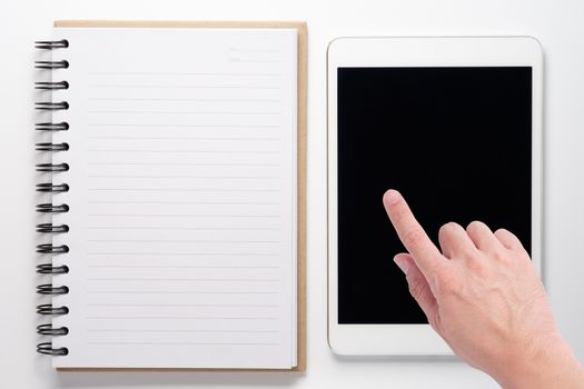 Notebook and tablet on white background with hand touch on tablet screen