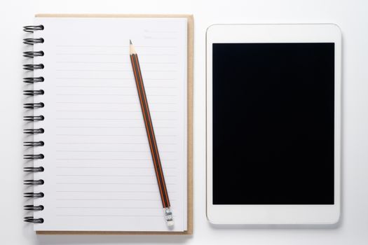 Notebook and tablet on white background.