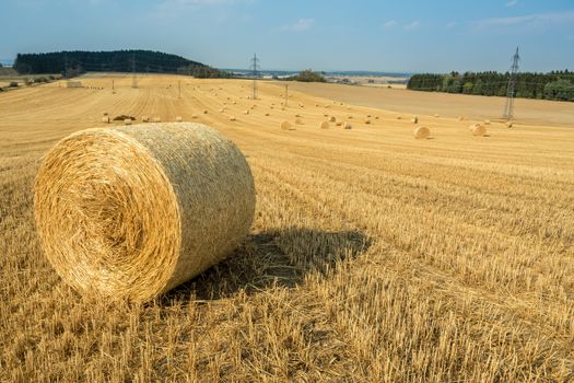 Beautiful landscape with straw bales in harvested fields, Czech Republic, Vysocina with blue sky and clouds