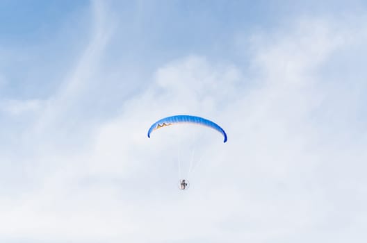 Paramotoring or microlight, paragliding against a blue sky.