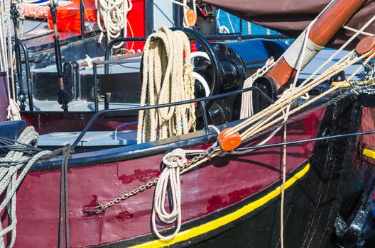 Close up of a ship's rail of an old wooden sailing boat. rope to a sailing mast.